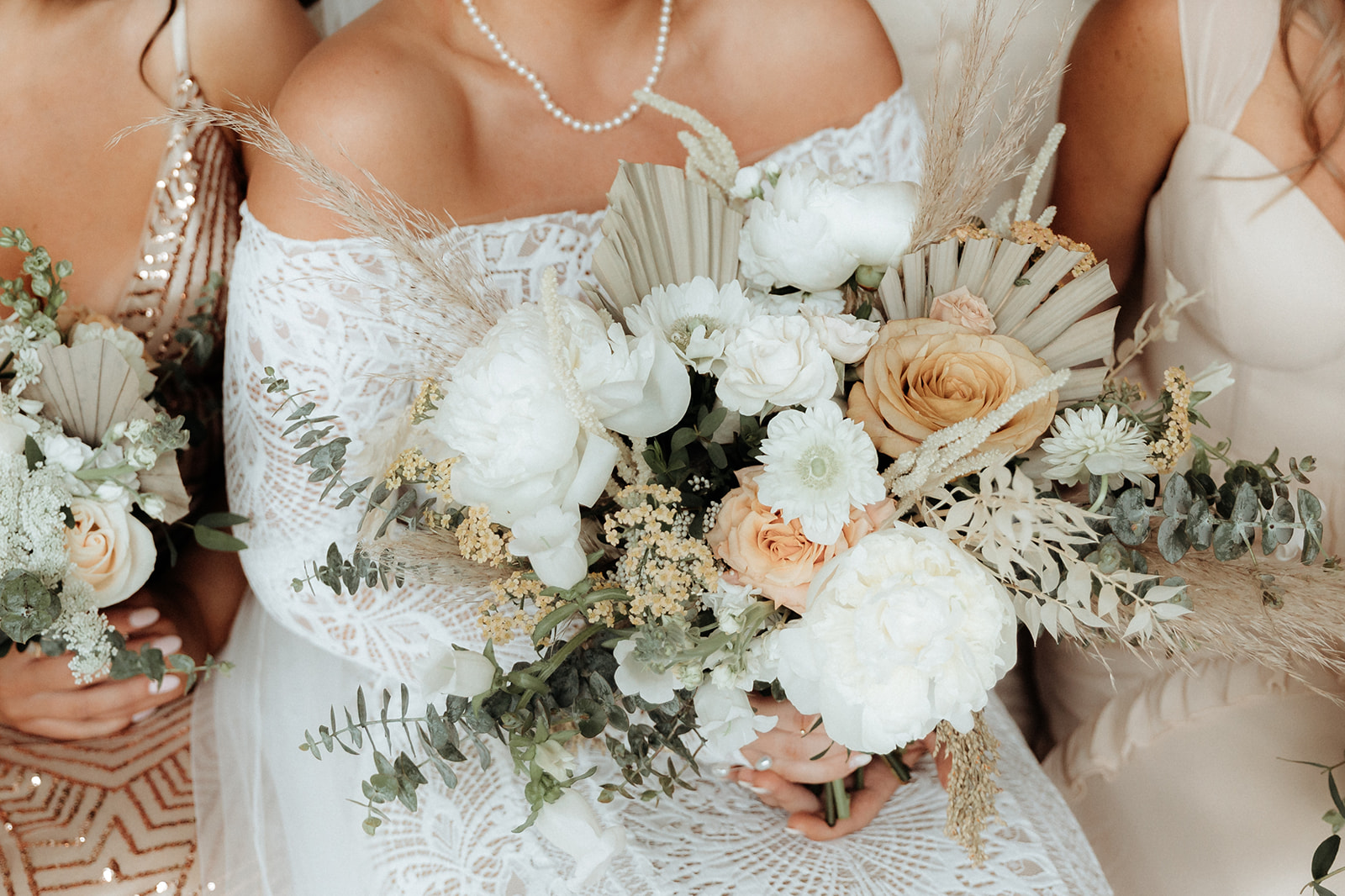 Detail photo of neutral palette bridal bouquet with white roses, eucalyptus, and dried elements.