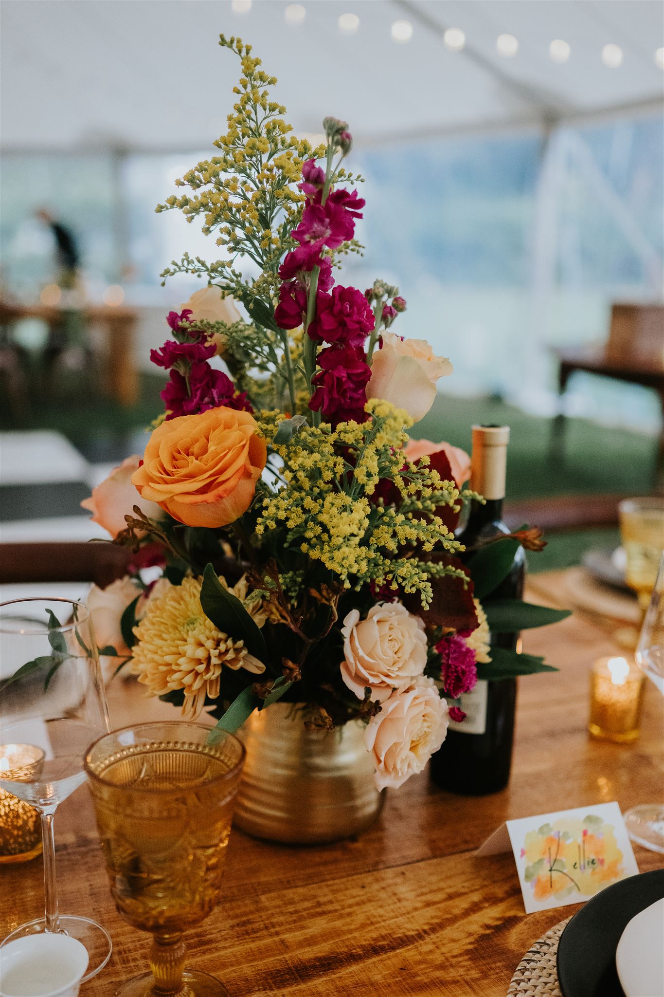 A wedding flowers centerpiece with orange, yellow, peach, and magenta.