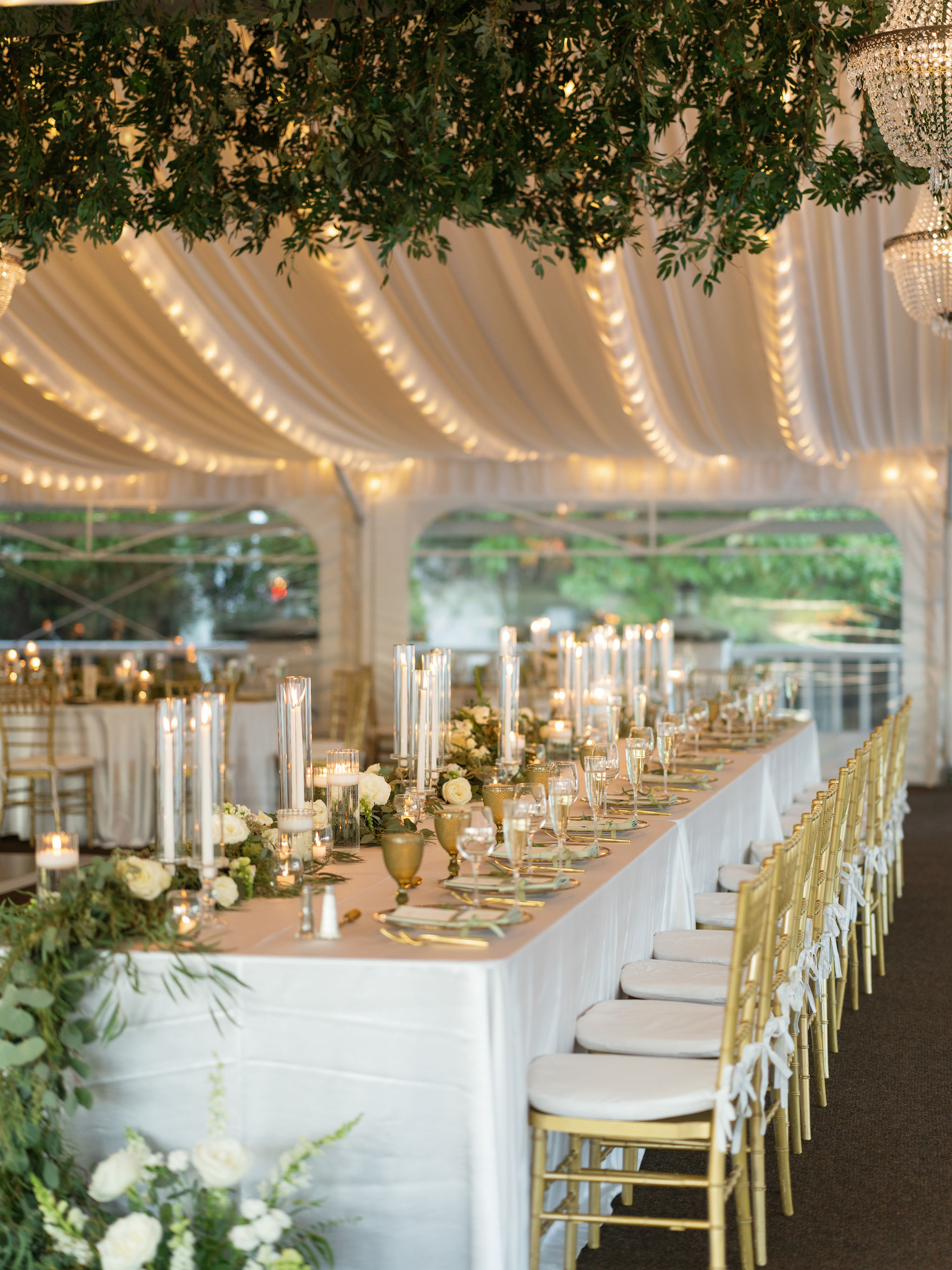 Wedding head table at the Sagamore with a white floral and greenery garland and taper candles.