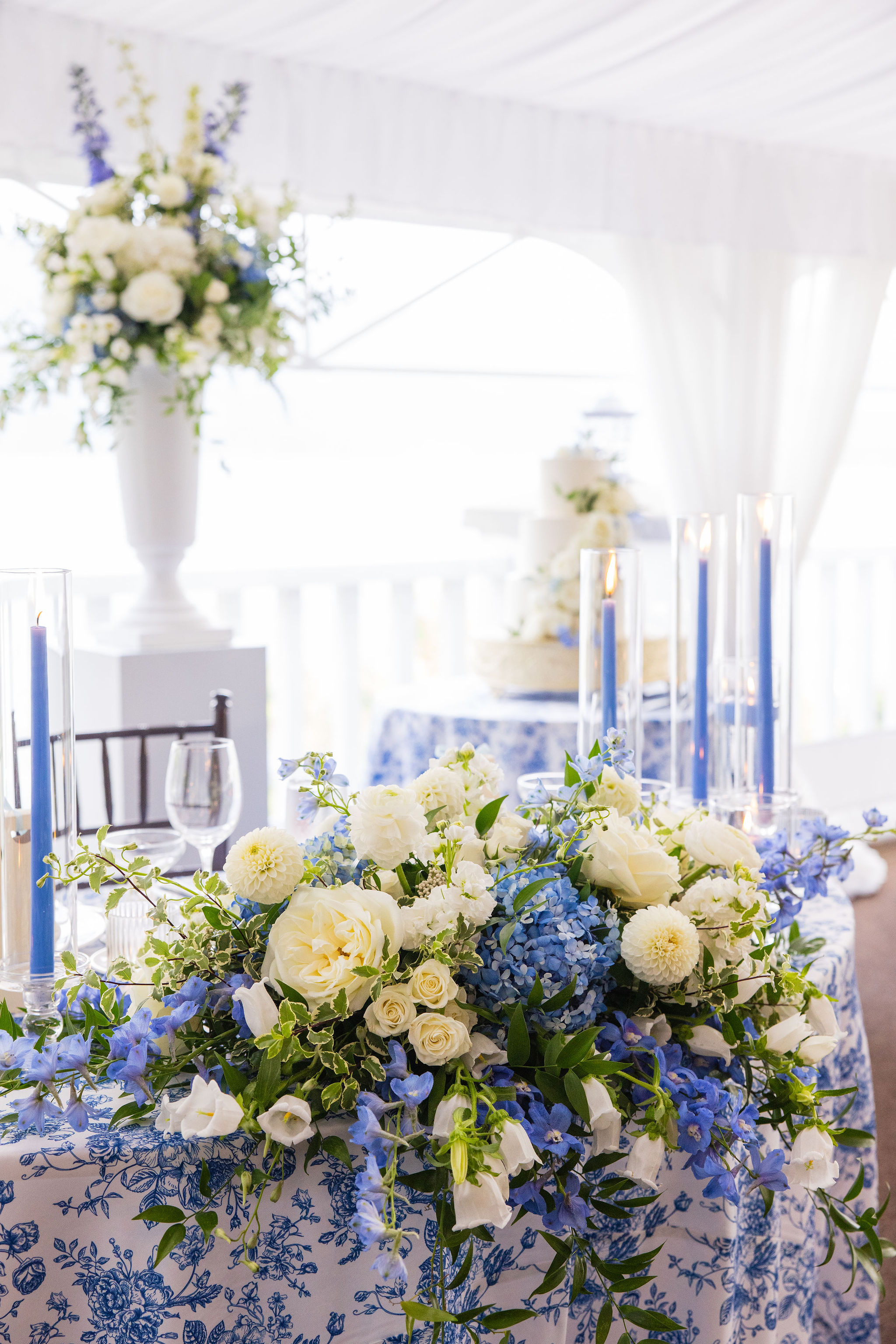Sweetheart table at The Sagamore Resort, with blue and white floral arrangements and table linens.