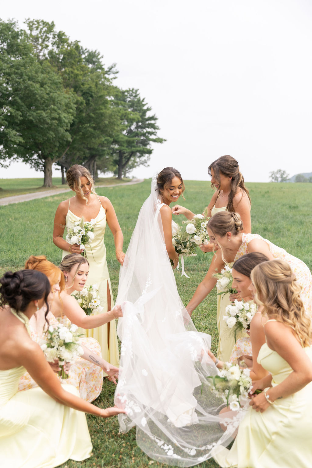 A bride and her bridesmaids in a field outside the Sablewood.
